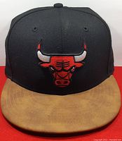 Front view of Chicago Bulls cap with black crown and brown suede brim showing embroidered bulls logo
