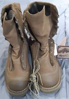 Front view of the tan Danner military boots showing high ankle design, metal eyelets, lace, and overall condition.