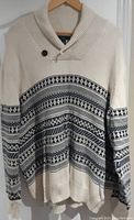 Full view of the cream sweater with navy and black Fair Isle pattern, showing shawl collar and button detail