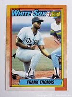 Front of 1990 Topps Frank Thomas rookie baseball card in white Chicago White Sox uniform, orange border, Draft Pick logo.