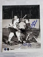 Full view of black and white 8x10 photo with Henri Richard and Johnny Bower during hockey game, showing prominent dual blue ink signatures