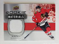 Front of Upper Deck Rookie Materials hockey card featuring Kirby Dach in Blackhawks uniform, showing the embedded white jersey swatch patch.