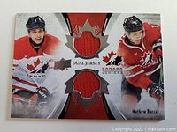 Card showing Matt Barzal and Ryan Strom in Team Canada Juniors uniforms with two embedded red jersey pieces shaped like maple leaves.