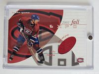 Front of the card showing Saku Koivu in Montreal Canadiens uniform with embedded red game-used jersey fabric.