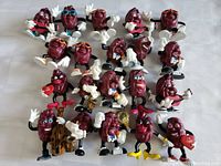 Photo of 21 California Raisins Clamation figurines in various poses, styles, and accessories.