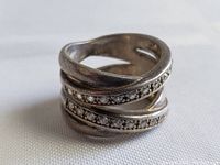 Front angle view showing the spiral multi-band design and inlaid clear crystals.