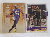Two NBA basketball cards: Kobe Bryant InkCore Score card and LeBron James Optic card, both Lakers.