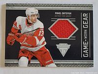Front view of NHL Pavel Datsyuk hockey card showing player image and embedded red game-worn jersey fabric piece.
