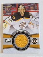 Front of trading card showing Tuukka Rask in goalie gear with Boston Bruins logo and circular yellow jersey swatch.