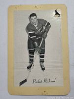 Front view of the vintage 1960s black and white Henri Richard hockey card showing the player in Montreal Canadiens uniform holding a hockey stick with 'Pocket Richard' printed at the bottom. The card is mounted on paper with visible wear and tear.