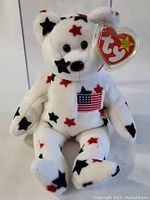 Original Ty Beanie Baby 'Glory' bear with red, white, and blue star pattern and American flag embroidered, showing the front view with tag visible.