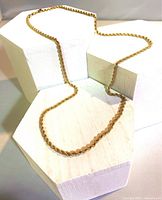 Rope chain draped over white geometric blocks