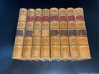 Eight leather bound volumes of Cowper’s Life and Works from 1847 with gold embossed detailing and red and dark brown title spine labels.