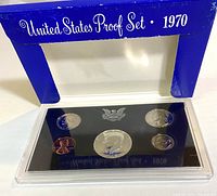 1970 United States Proof Set in blue cardboard sleeve with visible packaging wear and plastic holder containing five coins