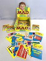 MAD Magazine branded display box with multiple sticker cards in front and inside the box showing colorful graphic designs.