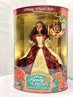Front view of the sealed Mattel Disney's Beauty and the Beast Holiday Princess Belle doll in original packaging showing the detailed gown and holiday ornament included.