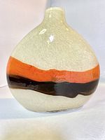 Front view of large handblown glass oval vase showing cream base with orange and brown bands and textured glass surface.