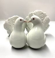 Front view of the Lladro porcelain figurine showing two white doves with detailed tails facing forward.