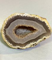 Full view of the white quartz agate geode showing the banded agate layers and crystalline cavity.