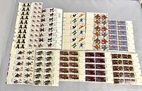 Top view photo showing multiple blocks of unused U.S. stamps arranged side by side, clearly showing various colorful designs including teddy bears, flags, sports and holiday themes.
