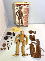 Vintage Johnny West kit in box with separated figure parts, accessories, and instruction manual laid out.