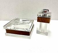 Front view of the Lucite lighter and ashtray side by side on a white surface