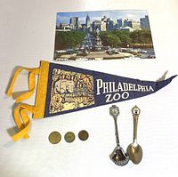 Lot layout showing Philadelphia Zoo pennant, three tokens, two souvenir spoons, and a cityscape postcard
