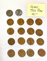 Top-side view of 18 pennies arranged on white surface, 2 steel pennies on top row, followed by 16 wheat pennies showing wear and patina.