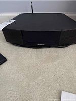 Front and top view of black Bose Wave Music System with CD slot and FM antenna