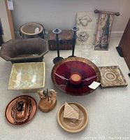 Overview of lot items on carpet including bowls, coasters, candlesticks, copper butter dish, boxes and other decorative objects.