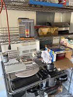 Wire shelving unit holding boxed appliances and kitchen items