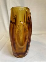 Front view of amber glass vase showing lens design and shape.