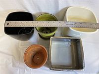 Top-down view of 5 planter pots with ruler showing measurement of approximately 6 inches for largest pot.