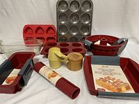 Lot showing silicone bakeware, bamboo salt box, measuring cups, metal muffin tin, and glass baking dish.