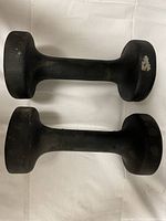 Two 10lb black dumbbells shown horizontally, hexagonal ends with minor paint wear