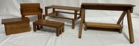 Group photo of all six miniature wooden furniture items including swing, picnic bench, coffee table, chair, and wood box, showing scale and condition.