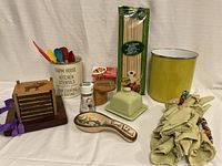 Wooden coaster set with wooden stand, ceramic spoon rest, salt shaker, covered butter dish, colorful kitchen utensils in utensil holder, napkins with rings, and package of spaghetti pasta
