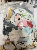 Plastic bag filled with assorted fabric scraps of various colors, including prints and solids