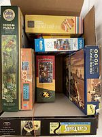 View inside box showing 8 assorted puzzle boxes with various themes and piece counts