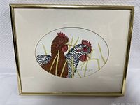 Front view of original framed watercolor painting depicting two roosters in muted tones with oval mat and gold-tone frame