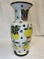 Front angled view of vintage ceramic vase showing fruit, leaf and geometric designs