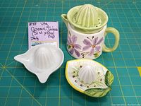 Photo showing all three lemon juicers and floral cup from a top-front angle, highlighting details, colors, and condition.