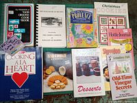 Lot of 10 cookbooks shown from a top-down perspective, titles visible including Christmas Cookies, Bar Cookie Bonanza, and Pedaling Through Provence by Sarah Leah Chase.