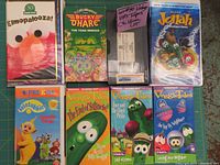 Full view of 8 different VHS tapes for children with covers including Sesame Street, Veggie Tales, Bucky O'Hare, Jonah, and Teletubbies