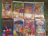 Photo showing all 8 VHS tapes in lot, colorful covers clearly show titles: A Christmas Carol, How The Grinch Stole Christmas, Thumbelina, Toy Story, Fantasia, The Lion King, Barney's Great Adventure, Cinderella.