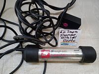 Photo of Snap-On Rugged Duty shop lamp showing branding and product label with specifications and power cord.