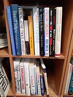 Books arranged on a wooden shelf showing titles focused on mind, emotional intelligence, business, and personal success topics.