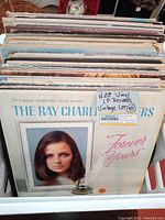 Photo showing a row of vintage LP vinyl records with 'The Ray Charles Singers - Forever Yours' album visible on front.