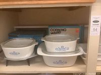 Lot on shelf showing warming stand with casserole and separate stack of covered and uncovered casseroles