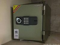 Front view of the grey steel safe showing door, hinges and placement